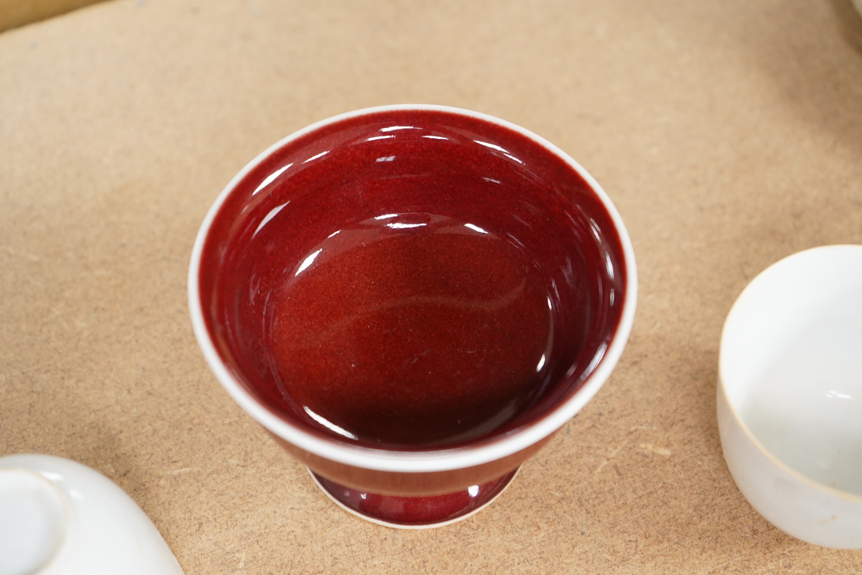 A Chinese red glazed stem cup together with two white glazed tea bowls, tallest 6.5cm